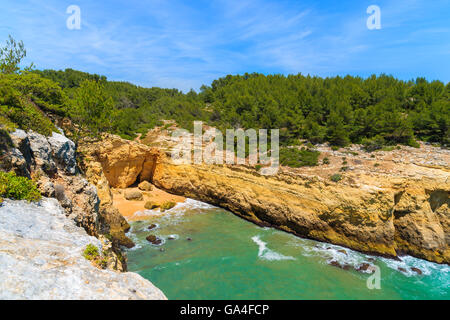 Appartata spiaggia nella baia con pareti rocciose a strapiombo sulla costa della regione di Algarve, PORTOGALLO Foto Stock