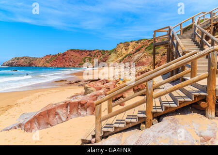 Gradini in legno a Praia do Amado spiaggia con le onde del mare di colpire a riva, regione di Algarve, PORTOGALLO Foto Stock