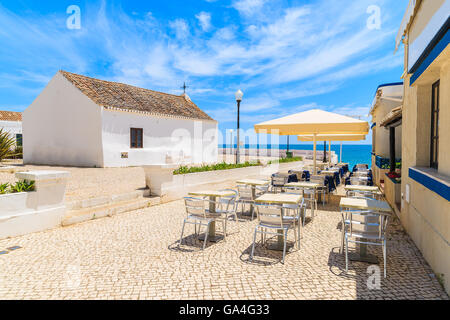 Chiesa e ristorante sul lungomare costiero nella cittadina balneare di Armacao de Pera, Portogallo Foto Stock