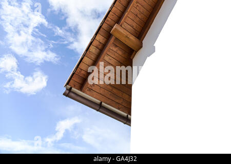 Tetto con travi a vista e nel gesso parete di casa contro il cielo nuvoloso Foto Stock