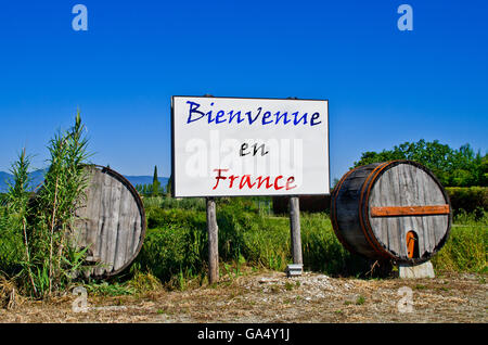 Affissioni strada circondata da due botti da vino per accogliere i turisti che vengono a visitare la Francia Foto Stock