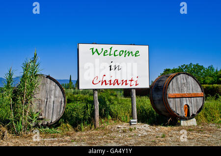 Affissioni strada circondata da due botti da vino per accogliere i turisti che vengono a visitare il Chianti Foto Stock