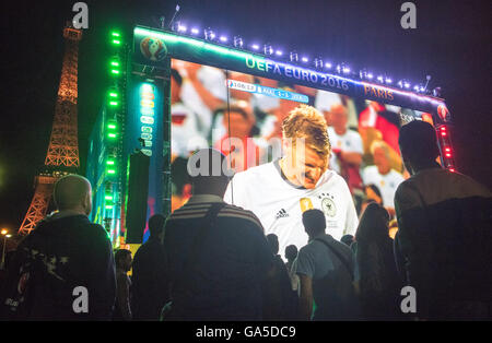 Parigi, Frabce, 2 luglio, 2016. Una folla di tifosi di guardare la trasmissione in diretta del quarto di finale di partita tra Germania e Italia (sede Bordeaux) davanti alla Torre Eiffel a Parigi, Francia 02 luglio 2016. Il gioco è presentato su un 432 metro quadrato sullo schermo. La Germania ha vinto contro Italia con 6:5 Punteggio ottenuto da sanzioni. Credito: dpa picture alliance/Alamy Live News Foto Stock