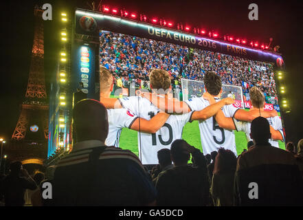 Parigi, Frabce, 2 luglio, 2016. Una folla di tifosi di guardare la trasmissione in diretta del quarto di finale di partita tra Germania e Italia (sede Bordeaux) davanti alla Torre Eiffel a Parigi, Francia 02 luglio 2016. Il gioco è presentato su un 432 metro quadrato sullo schermo. La Germania ha vinto contro Italia con 6:5 Punteggio ottenuto da sanzioni. Credito: dpa picture alliance/Alamy Live News Foto Stock