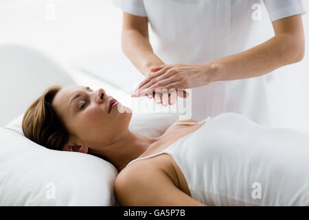 Theparist eseguire trattamento reiki sulla donna Foto Stock