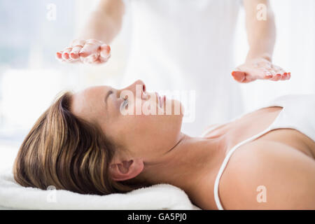 Sezione mediana del terapista esegue trattamento reiki sulla donna Foto Stock