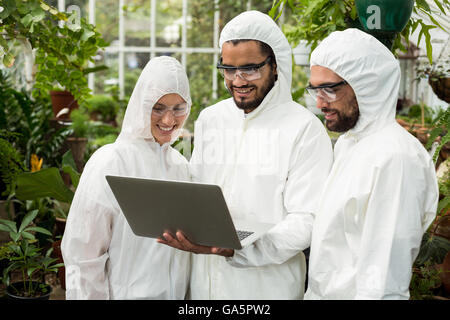 Gli scienziati a discutere su laptop Foto Stock