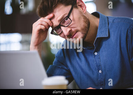 Ritratto di imprenditore che soffrono di mal di testa in ufficio Foto Stock