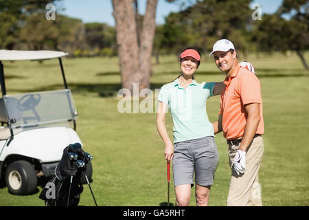 Ritratto di smart golfista giovane con braccio intorno a Foto Stock