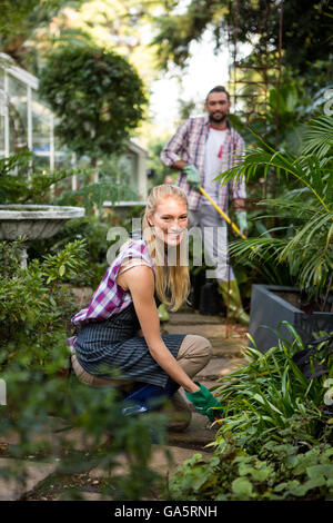 Ritratto di giardiniere femmina con un collega nella comunità giardino Foto Stock