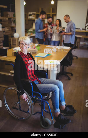 Ritratto di giovane imprenditrice disabili dalla scrivania Foto Stock