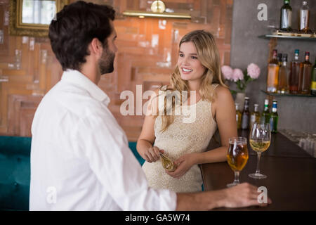 Matura in piedi con un bicchiere di vino davanti al bancone bar Foto Stock