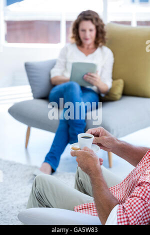 Sezione mediana di uomo con tazza di caffè a casa con la donna Foto Stock