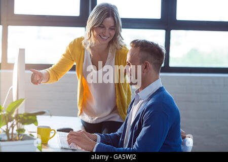Felice i colleghi che lavorano in ufficio Foto Stock