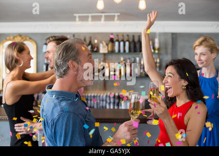 Gruppo di amici tenendo un bicchiere di champagne flute mentre balli Foto Stock