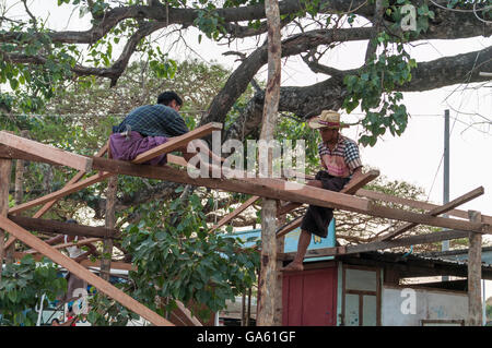 Carpentieri di lavoro su una casa sito in costruzione in Myanmar. Foto Stock