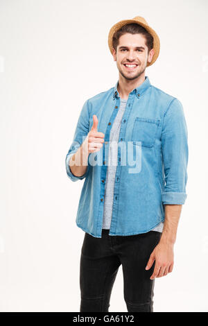 Allegro giovane uomo che mostra pollice in alto isolato su sfondo bianco Foto Stock