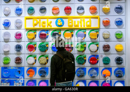 Un uomo seleziona i mattoni dalla sezione Pick and Build del negozio Lego, Copenhagen, Danimarca Foto Stock