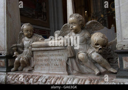 Una tomba scolpita con due putti, una holding di una clessidra e l'altra, un cranio. Iscrizione in latino Foto Stock