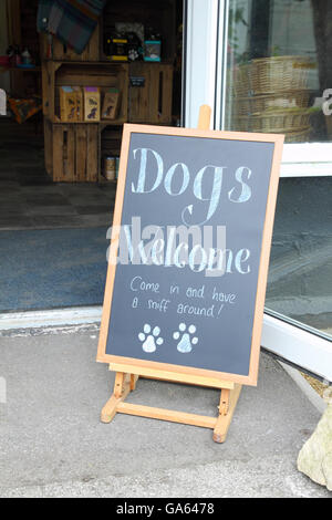 'Dogs Benvenuti' firmare al di fuori di un prt forniture shop al villaggio Blakemere, Cheshire. Foto Stock