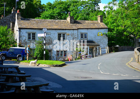 Tradizionale antica cartello stradale ed edifici in Malham Cove, Yorkshire Dales National Park, vicino a Settle, West Yorkshire Foto Stock