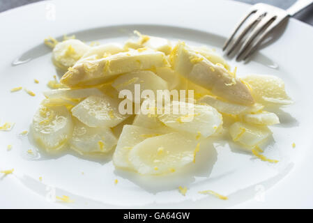 Bianco crudo Insalata di asparagi con limone zests su una piastra Foto Stock