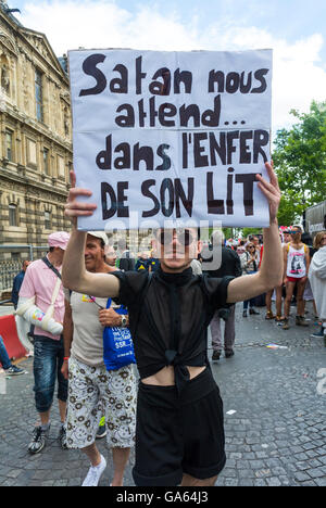 Parigi, Francia, Young Adult Man Holding Protestation Sign al French Gay Pride, attivismo di protesta LGBTQ, "The Devil is waiting for Us, in Hell, in His Bed", cartellone per i diritti dei gay, proteste per i diritti dei gay Foto Stock
