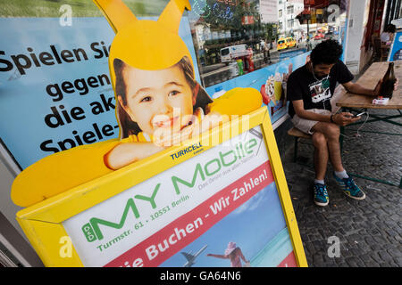 Pubblicità per Turkcell Turkish società di telefonia mobile al di fuori di negozi Neukolln Berlino Germania Foto Stock