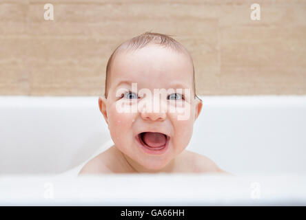 9 mesi baby boy divertirsi nella vasca da bagno Foto Stock