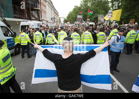 Un pro-Israeliano sostenitore tiene la bandiera di Israele, come la polizia contengono pro-palestinese sostenitori come essi prendono parte in un rally nel centro di Londra, per commemorare la Al-Quds giorno, un giorno che è stato segnato in tutto il mondo poiché essendo inaugurato nel 1979 dall Ayatollah Khomeini ha chiesto che l' ultimo venerdì in islamica del mese sacro del Ramadan per essere messo da parte come un giorno per unire contro Israele e che mostra il supporto per i palestinesi. Foto Stock