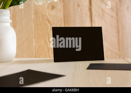 Blanck black business card e fiori sulla scrivania con sfondo a strisce Foto Stock