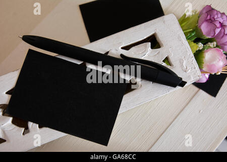 Blanck black business card e fiori sulla scrivania con sfondo a strisce Foto Stock