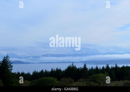 Il cielo blu e stagliano albero linea di Bearreraig Bay. Foto Stock