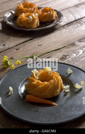 Mini torta di carote con il cioccolato bianco su una tavola in legno rustico. Foto Stock