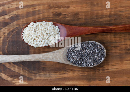 Semi di sesamo e nero semi di chia in cucchiai di legno vista superiore Foto Stock