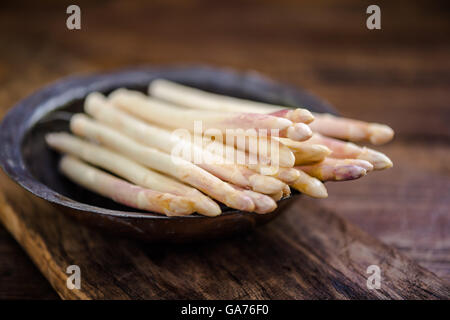 Asparagi bianchi in stile rustico ciotola sul tavolo di legno Foto Stock