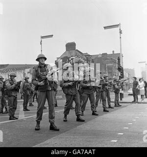 Una linea di truppe britanniche si levano in piedi in guardia nella zona di Falls Road di Belfast strappato riot. Foto Stock