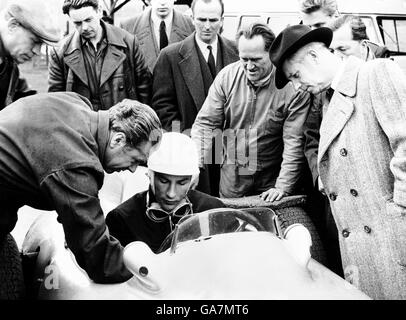 Corse automobilistiche. Stirling Moss prende un po' di consiglio dal team manager Mercedes Alfred Neubauer (l), mentre seduto nella sua Mercedes Benz Foto Stock