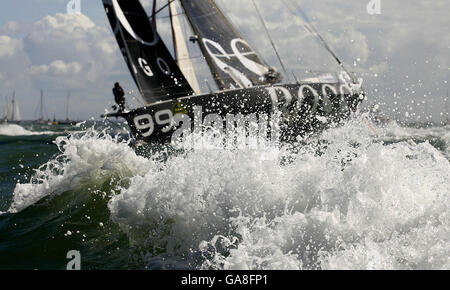 Hugo Boss di Alex Thomson all'inizio della Rolex Fastnet Race sul Solent vicino a Cowes, Isola di Wight. Foto Stock