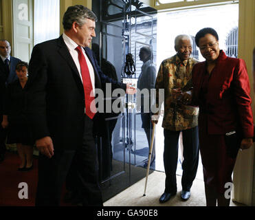 Il primo ministro britannico Gordon Brown accoglie con favore l'ex presidente sudafricano Nelson Mandela, insieme a sua moglie Graca Machel, nel 10 Downing Street, Londra. Foto Stock