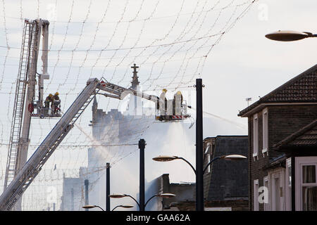 Great Yarmouth, Regno Unito. 5 Ago, 2016. I vigili del fuoco che frequentano il fuoco in un mercato coperto e pista da bowling in Great Yarmouth. Unità di vendita al dettaglio e una famosa pista da bowling sono stati tutti distrutti durante gli incendi scoppiati intorno a 3AM sulla zona pedonale Regent Road causando i residenti nelle vicinanze per essere evacuata. Credito: Adrian Buck/Alamy Live News Foto Stock