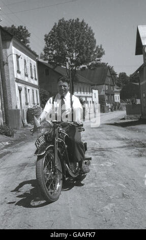 1930s, storico locale di uomo che indossa bretelle e plus fours ma con pantofole in mostra con orgoglio il suo nuovo CZ bici del motore su una corsia nel villaggio di Lauterbach nel Sudetenland, in pre-WW11 Cecoslovacchia. Foto Stock