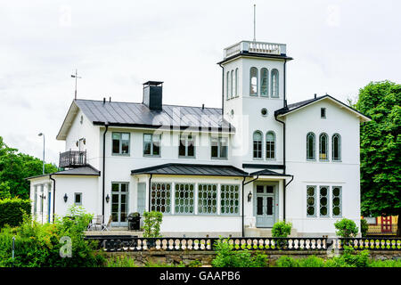 Motala, Svezia - 21 Giugno 2016: incantevole edificio bianco che si trova lungo la Gota canal in città. Ha una piccola torre di vedetta. Foto Stock