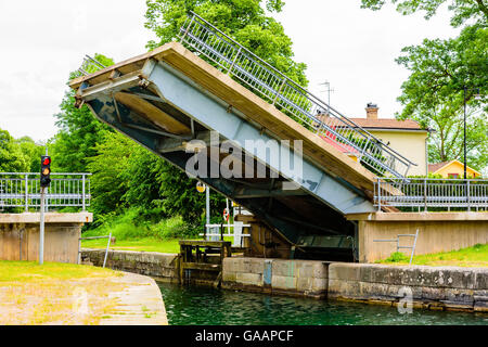 Una sezione di una strada che attraversa un canale viene sollevato come un ponte mobile. Il traffico di segnale di luce per barche di fermarsi e di essere pronto per Foto Stock