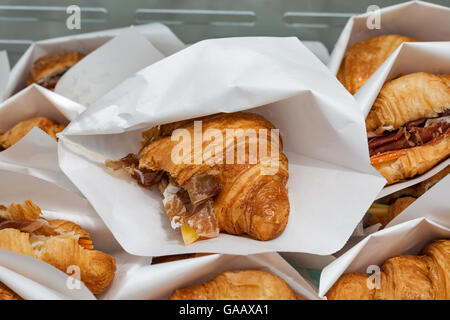 Cucina di strada croissant con prosciutto e formaggio servita in sacchi di carta closeup Foto Stock