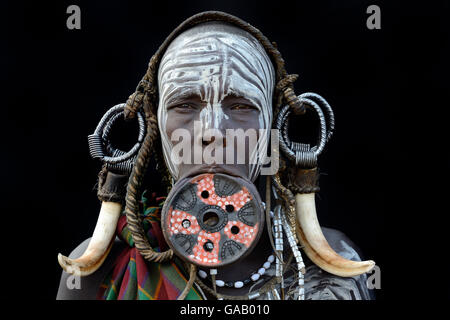 Ritratto di una donna dalla tribù dei Mursi, tradizionalmente decorate e dipinte, indossando un grande labbro di argilla piastra, Valle dell'Omo, Etiopia, marzo 2015. Foto Stock