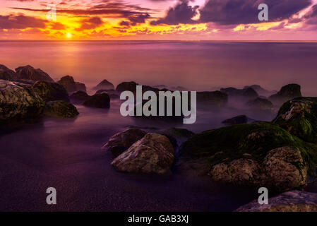 Colorato sfondo viola del tramonto sulla riva del mare Foto Stock