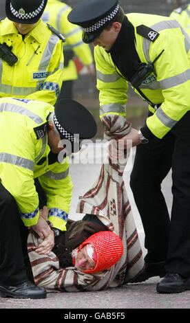 Un protestante è portato via dalla polizia alla base navale di Faslane durante l'ultimo giorno di un anno di protesta anti nucleare al sito. Foto Stock