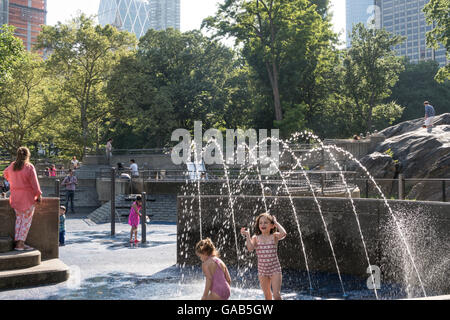 I bambini si divertono gli sprinkler in Heckscher parco giochi, al Central Park di New York Foto Stock