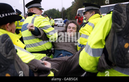 Un protestante è portato via dalla polizia alla base navale di Faslane durante l'ultimo giorno di un anno di protesta anti nucleare al sito. Foto Stock